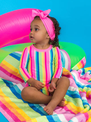 RuffleButts + RuggedButts - Baby Girls Neon Rainbow Stripe Long Sleeve One Piece Rash Guard Swimsuit with Signature Rear Ruffles